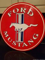 Front view of the round metal Ford Mustang sign showing the logo and text clearly.