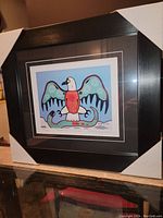Full view of the framed fine art print in a black frame with corner protectors.