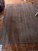 Photo of one IKEA jute rug showing the natural brown textured woven surface on wooden floor.