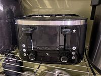 Front view of black and stainless steel two-slice toaster with control knobs and buttons