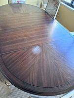 Close-up image of the vintage oval dining table top showing wood veneer pattern and finish.