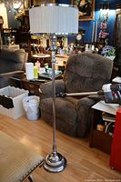 Full view of the 1930s chrome pole floor lamp with fabric shade in a living room setting.