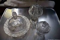 Photo of three crystal candy dishes with lids on a metal tray showing the full lot.