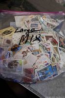 Clear plastic bag filled with assorted used postage stamps from various countries, labeled 'Large Mix'.