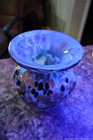 Side angle of the blue Murano glass vase showing gold and black flecks embedded in the glass with a rounded body and flared rim.