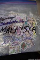 Resealable bag labeled 'Malaysia' containing assorted used Malaysian stamps including floral and fauna themes