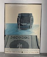 Full front view of framed poster showing chair and rug image with exhibition text below