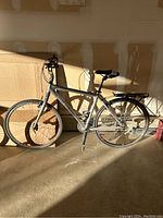 Side profile of a silver Trek 7500 men’s bicycle showing full frame, wheels, pedals, rear rack.