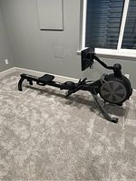 Side view of NordicTrack RW700 rowing machine showing black frame, seat, rail, and console