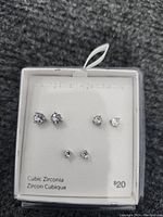 Photo of three pairs of sterling silver cubic zirconia stud earrings on original packaging card indicating $20 price.