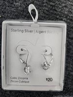 Photo of sterling silver cubic zirconia earrings in white box with price tag showing $20 and label 'Sterling Silver | Argent Sterling'
