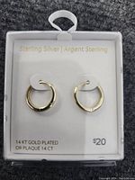 Pair of sterling silver 14KT gold plated hoop earrings in original packaging with product details and price.