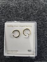 Pair of sterling silver 14K gold plated hoop earrings on white display card with inscription "Sterling Silver | Argent Sterling" and "14 KT GOLD PLATED OR PLAQUE 14 CT"
