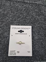 Photo showing sterling silver ring size 7 mounted on a branded card with label 'STERLING DESIGNS Argent Sterling Silver', indicating 14K gold plating and nickel free.