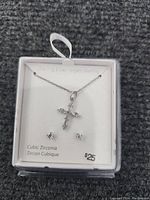 Photo of sterling silver necklace with cross pendant and cubic zirconia stud earrings in white box