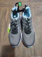 Pair of women's gray athletic shoes from top view showing size 9 tag and polka dot laces.