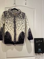 Front view of the black and white cosy jacket showing speckled design and high collar.