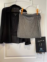 Grey Forever 21 skirt and black U2B blouse with tank hung on hangers photographed against a white door.