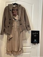 Pullover taupe shirt with tweed look hooded jacket hanging on a door, showing both items full front.