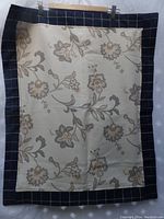 Photo of custom-made pillow sham showing floral front with blue plaid border and backing.