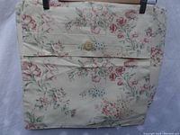 Front view of one small rectangular pillow cover in floral cotton fabric, featuring a wooden button closure on the back.