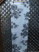 Full view of the folded curtain fabric showing the floral pattern on light fabric.