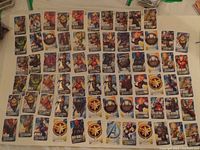 Photo showing multiple Marvel trading cards laid out in rows, featuring various superheroes and logos.