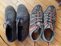 Pair of men's gray Geox casual shoes and men's gray and orange Ecco shoes seen from above on wooden floor