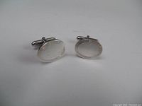 Front view of both oval cufflinks on white background
