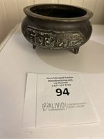 Front view of the bowl showing decorative Chinese pattern on the side and three legs.