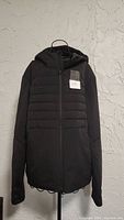 Front view of the black Lululemon women's hooded jacket on hanger, showing full length and zipper closure.