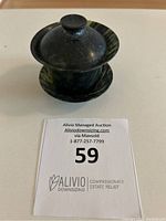 Fully assembled gaiwan made of natural black and green jade with lid, bowl and saucer, photographed from above.