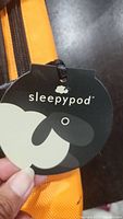 Close up of Sleepypod branded black and white sheep logo tag attached to the carrier.