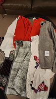 Overview of women's sweaters and cardigans laid out on table showing variety of colors and patterns