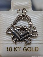 Close-up image of a 10K gold diamond pendant showing design detail and bail.