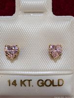 Front view of the pair of heart-shaped CZ earrings in 14K gold setting displayed on a white card labeled '14 KT. GOLD'