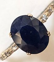 Close-up of oval blue sapphire and diamond-accented band