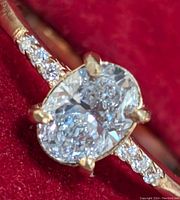 Top view of ring showing oval center diamond and pave-set round diamonds on band