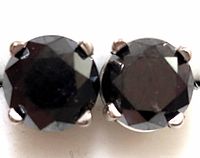 Close-up front view of both round black diamond stud earrings in prong settings