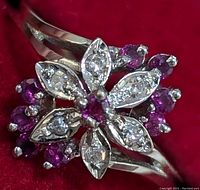 Top-down view of ring showing flower cluster design of diamonds and rubies