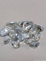 Multiple faceted oval aquamarine gemstones with light blue transparency and clear faceting.