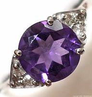 Close-up front view of amethyst and diamond accents showing the deep purple faceted amethyst gemstone and small diamonds in triangular side settings