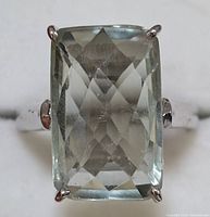Front view of the rectangular pale green amethyst stone set in silver prongs on the ring.