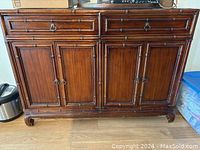 Front view of faux bamboo style sideboard showing drawers and cabinet doors