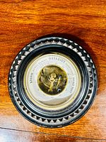 Top view of the antique Swedish wall barometer showing detailed carved wood frame and brass inner mechanism beneath glass cover.