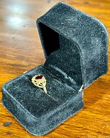 Ring displayed in black velvet presentation box on wood surface