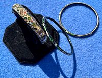 Three vintage mosaic bangles displayed on a black stand and a blue background showing overall design and colors.