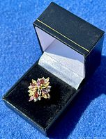 Ring displayed in black presentation box on blue background.