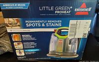 Front of box showing Bissell Little Green ProHeat carpet and upholstery deep cleaner, highlighting permanent spot and stain removal and HeatWave Technology.