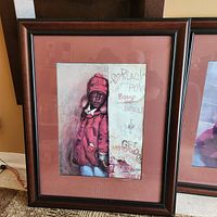 Full view of framed artwork showing child in red coat and graffiti wall